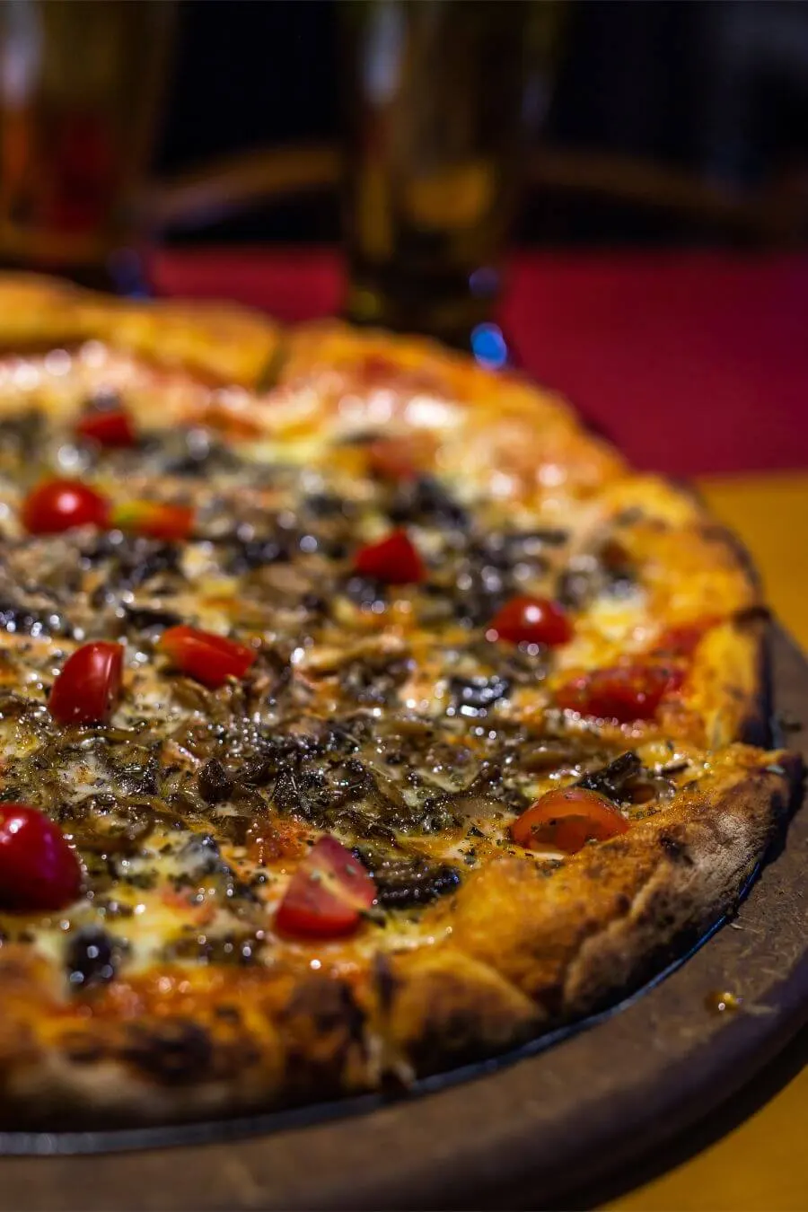Pizza recém-saída do forno, com o fogo aceso ao fundo